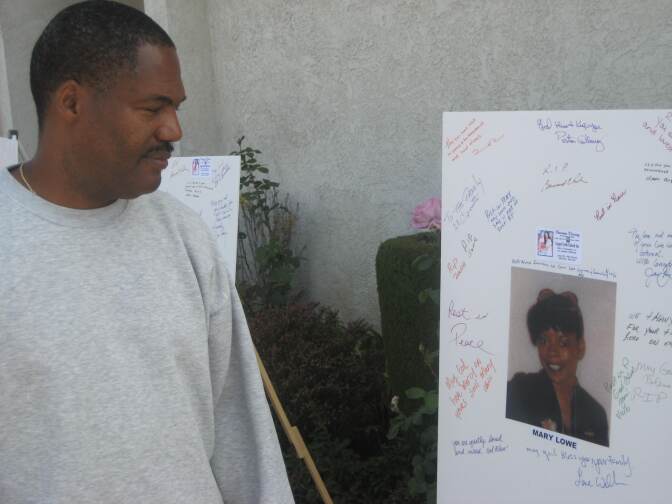 Chris McNair looks at the photo of Mary Lowe after writing "May God have mercy on your soul."