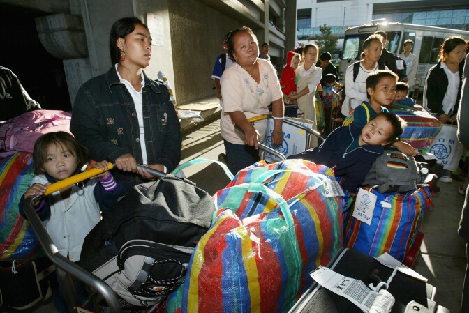 LOS ANGELES, CA - AUGUST 23:  Exhausted Hmong refugees get ready to board a bus for Fresno after arriving on the first chartered aircraft carrying 289 Hmong passengers to the Los Angeles airport on August 23, 2004 in Los Angeles California. Thousands of Hmong refugees who fled Laos for Thailand 30 years ago are preparing for a new life in America after the U.S government announced it was launching a resettlement program for up to 15,000 Hmong living in the refugee camp northeast of Bangkok. The actual movement of the Hmong from the camp to their new home, including medical screening, and necessary cultural orientation classes is facilitated by the International Organization for Migration (IOM). The Hmong who often live on the margins of society in Thailand have had many problems with food, health and education because of lack of money. Since the migration started, over 1,500 Hmong have departed so far to America. The historical migration to the USA will finally close a painful chapter for many of the refugees who had sought safety in Thailand after the Vietnam war where as many as 40,000 Hmong were fighting for the Americans in Laos.  (Photo by Paula Bronstein/Getty Images)