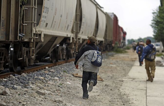 Salvadorean migrants run to jump on a train to the border with the United States, in Lecheria, 30 km north of Mexico City, on June 1, 2010. On a visit to Washington in May, Mexican President Felipe Calderon urged the US government to repair an outmoded immigration system and do more to ensure that illegal guns do not flow across the countries' shared border.  