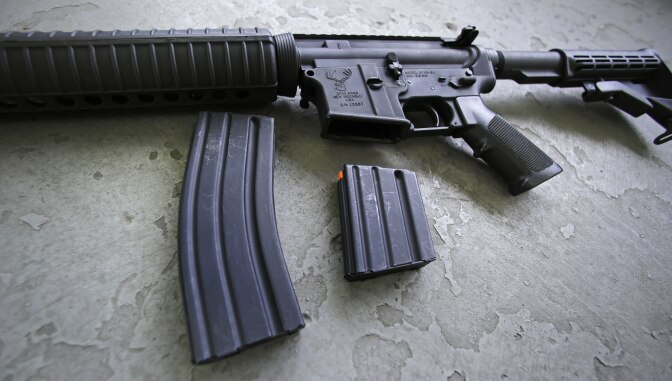A 30 round magazine, left, and a 10 round magazine, right, rest below an AR-15 rifle, similar to the weapon lost by an Orange County Sheriff's deputy Tuesday. 