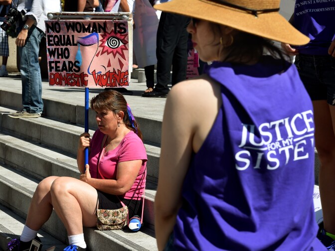 A woman protests against domestic violence as she joins other women's rights advocates in an International Women's Day march in downtown Los Angeles, California on March 8, 2015.