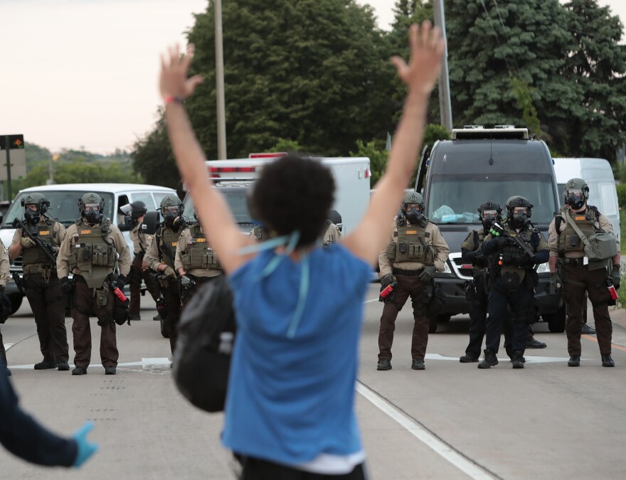 MINNEAPOLIS, MINNESOTA - MAY 31: A demonstrator holds her hands up in front of police while protesting against the death of George Floyd, on May 31, 2020 in Minneapolis, Minnesota. Protests continue to be held in cities throughout the country over the death of George Floyd, a black man who died while in police custody in Minneapolis on May 25. (Photo by Scott Olson/Getty Images)