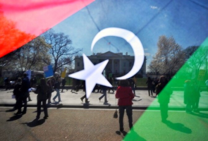 A man waves a Kingdom of Libya flag during an anti-war demonstration in front of the White House in Washington, DC, on March 26, 2011.