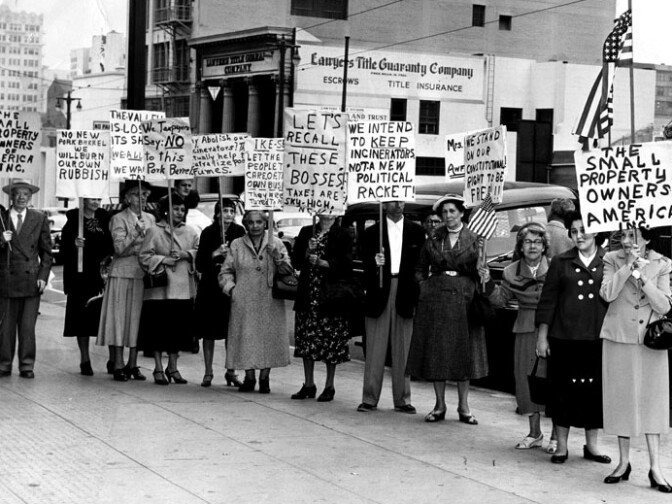 "Group photo of picketers holding plackards on the sidewalk. One of the signs reads, "No new pork barrel, we will burn our own rubbish," another reads, "We intend to keep incinerators, not a new political racket!" Photo dated: June 30, 1955." 