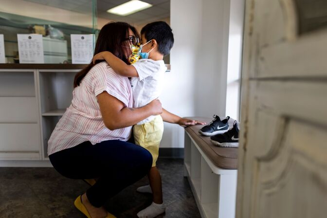 College student drops off her four year old son at the campus day care, they hug.