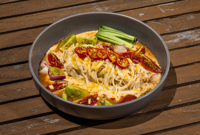 A bowl of the Korean dish Kongguksu with noodles, peppers and other vegetables.