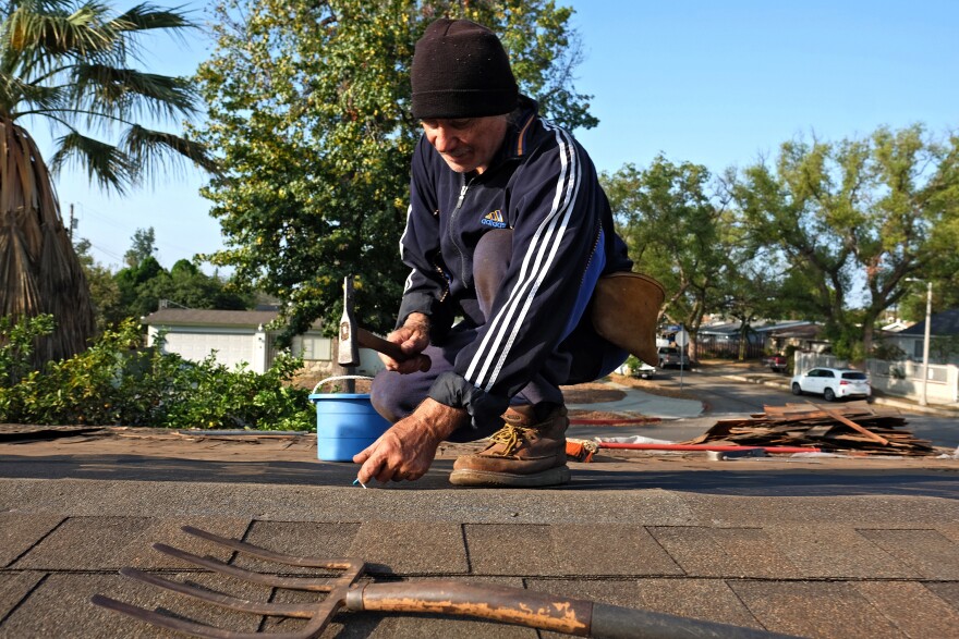 File: Roofer Michal Swiderski works on putting in a new roof of his home in the Panorama City section of Los Angeles on Saturday, Oct. 17, 2015. 