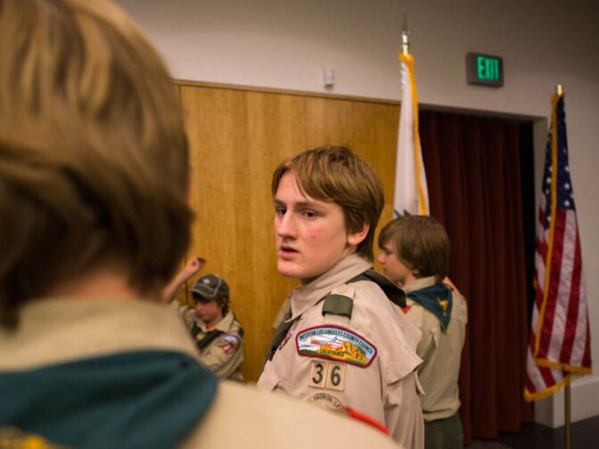 An older scout helps coach younger peers through a physical exercise at a meeting of Troop 36 in North Hollywood.