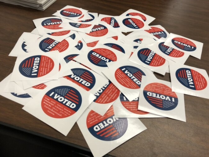An array of "I voted stickers" on a wood surface