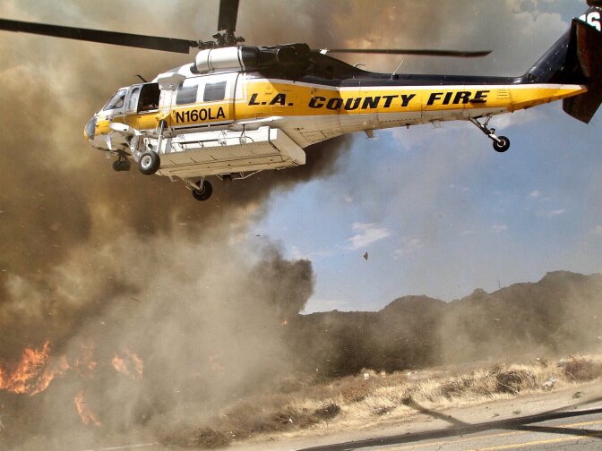 A helicopter from the L.A. County Fire Department provides air support to crews battling the La Tuna Fire burns in the hills above Burbank on September 2, 2017.