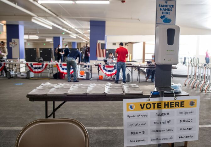 Masks and disinfectant are seen next to electoral booklets displayed in multiple languages at the Beverly Hills City Hall voting center set up in a parking garage on October 28, 2020, in Beverly Hills, California. (Photo by VALERIE MACON / AFP) (Photo by VALERIE MACON/AFP via Getty Images)