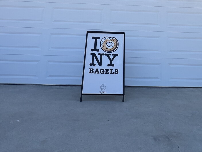A "I love NY bagels" sign in front of a garage door.
