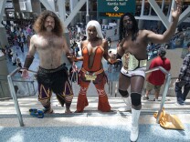 Kevin Booth, left, and Brittney Phillips are dressed as Meng Huo and Zhu Rong from the video game Dynasty Warriors 7 during the Anime Expo at the Los Angeles Convention Center. Aaron Wilson, right, came dressed as the WWE wrestler Booker T.