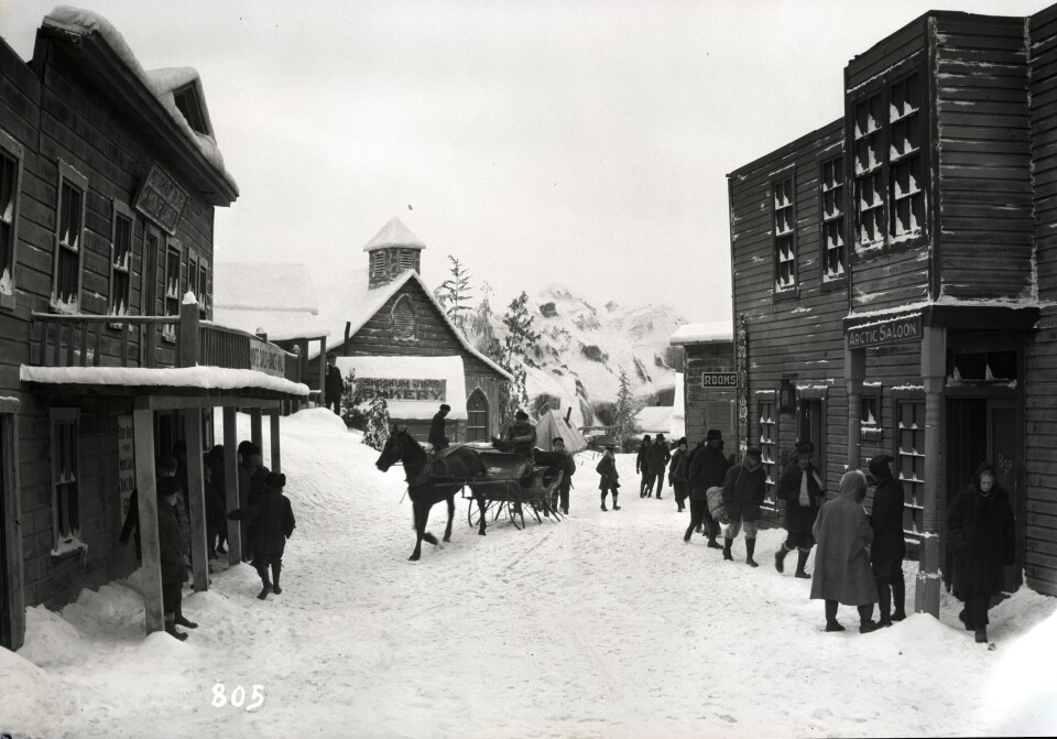 A black and white photo of a film set intended to look like a mining town. 