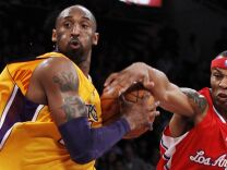 Los Angeles Clippers' Caron Butler, right, attempts to knock the ball away from Los Angeles Lakers' Kobe Bryant during the first half of an NBA preseason basketball game in Los Angeles.
