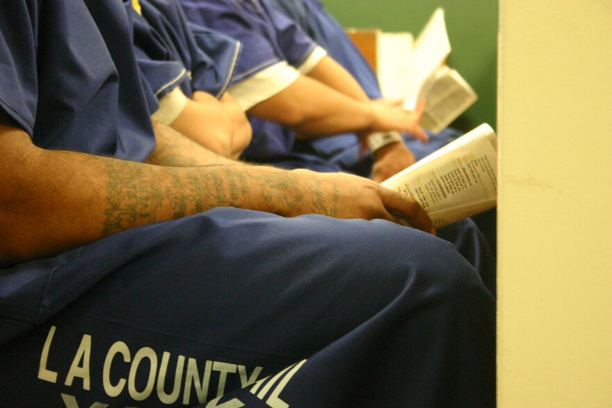 Inmates at Men's Central Jail follow along during the church service. 