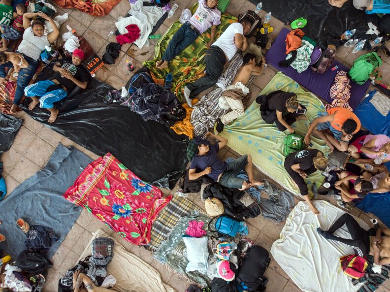 TOPSHOT - Aerial view of Honduran migrants taking part in a caravan heading to the US, as they rest in the main square of Pijijiapan, Chiapas state, Mexico, on October 25, 2018. - The Pentagon is expected to deploy about 800 troops to the US-Mexico border, two US officials told AFP on Thursday, after President Donald Trump said the military would be used there to tackle a "national emergency." (Photo by Guillermo Arias / AFP)        (Photo credit should read GUILLERMO ARIAS/AFP/Getty Images)