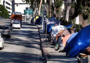 FILE - This Tuesday, Jan. 26, 2016 file photo shows tents from a homeless encampment line a street in downtown Los Angeles. Los Angeles city and county officials have approved sweeping plans to deal with homelessness at a cost of billions over a decade. The City Council's strategic plan calls for providing more housing and funding programs designed to keep people off the streets in the first place. The city has around 25,000 homeless, more than half the total in LA County. (AP Photo/Richard Vogel,File)