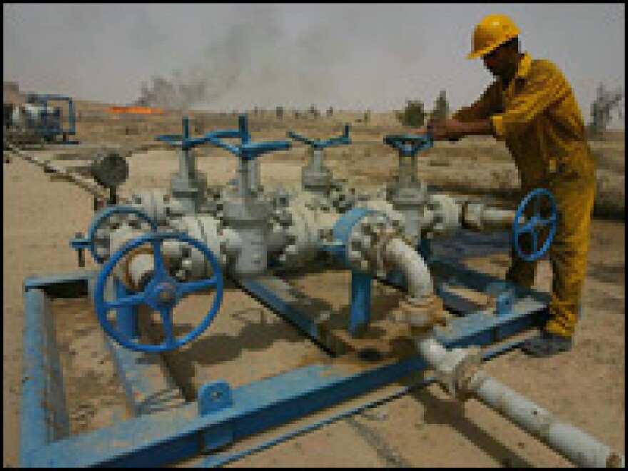 An Iraqi worker checks the valves at the Kirkuk oil field. Tuesday, the government of Iraq opens bids from oil companies interested in helping the country increase its oil production.