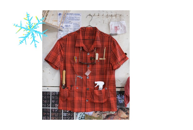 A red plaid shirt with various garden tools tucked inside many pockets.