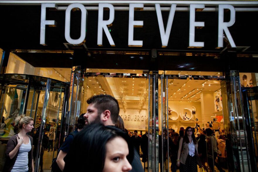 NEW YORK, NY - MARCH 23:  People walk past a Forever 21 store in Times Square on March 23, 2012 in New York City.  A recent study found that the Times Square district contributes up to 10% of all jobs in the city and is responsible for approximately 11% of economic activity.  (Photo by Andrew Burton/Getty Images)