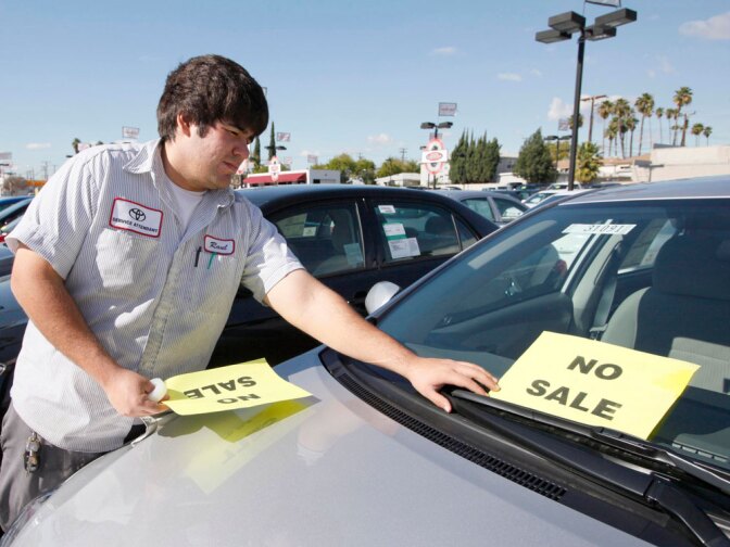 Employee Raul Quecada places a "No Sale" sign on a used Toyota vehicle at a Toyota dealership in Alhambra, Calif., on Jan. 27, one day after Toyota Motor Corp. announced it would halt sales of some of its top-selling models to fix gas pedals that could stick and cause unintended acceleration.