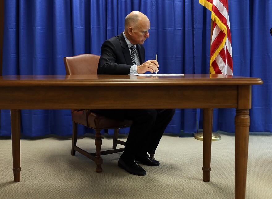 File: California Governor Jerry Brown prepares to sign copies of the California Homeowner Bill of Rights (AB 278 and SB 900) on July 11, 2012 in San Francisco, California. 