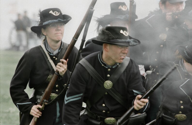 An Englishwoman, left, portrays a male Union soldier and fights alongside her husband during a reenactment in England.