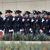 With black ribbons across their badge and holding a gun, police recruits attend their graduation ceremony at LAPD Headquarters where rappers Snoop Dogg and The Game led a peaceful demonstration outside on July 8, 2016 in Los Angeles, California, in what they called an effort to promote unity in the aftermath of the deadly shootings of police officers in Dallas.
 / AFP / Frederic J. BROWN        (Photo credit should read FREDERIC J. BROWN/AFP/Getty Images)