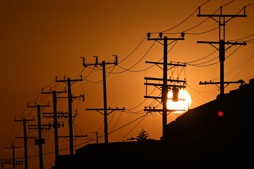 The sun sets and shows off the silhouettes of power lines.