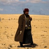 A Libyan rebel wearing an unsual combination of local and military outfits is pictured on March 22, 2011 where rebel forces massed for a second day on several kilometres from the key city of Ajdabiya to try to attack government forces that have encircled the town.