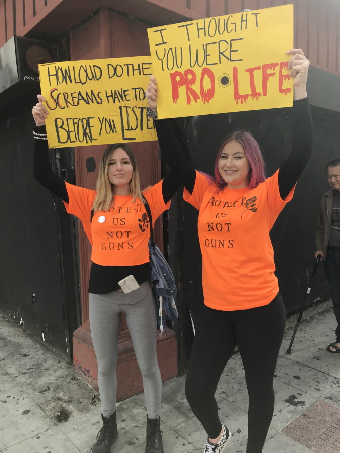 From left to right: Lia Grinsell and Maddy Croall, both students at Westlake High School hold up their signs at the March for Our Lives rally in downtown Los Angeles. 