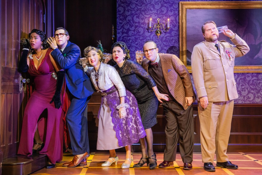 Actors of 'Clue playing telephone with a glass cup