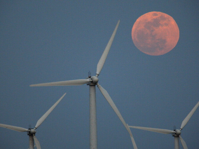PALM SPRINGS, CA - MAY 5:  A perigee moon, or supermoon, rises behind wind turbines on May 5, 2012 near Palm Springs, California. The moon appears especially big and bright during this once-a-year cosmic event as the full moon is at its closest to the Earth in its elliptical orbit. The perigee side of its orbit is about 31,000 miles closer than the opposite, or apogee, side. The bright light of the full moon also hides all but the brightest meteors of the Eta Aquarid meteor shower, the remnant debris trail of Halley's Comet.   (Photo by David McNew/Getty Images)