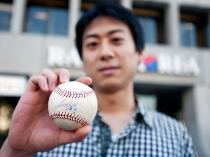 Chris Yi of Los Angeles holds a baseball that Ryu signed.