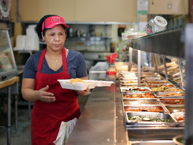 Enedina Arrellano, a cook at Poncitlan Burrito Express in Altadena, makes a to-go order for a customer on Thursday, March 27. The store first opened in 1992 as a convenience store with a meat counter and was called Poncitlan Meat Market.