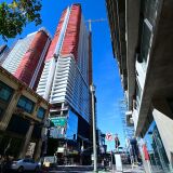 Pedestrians cross a street in Los Angeles, California on January 25, 2019 near the unfinished Oceanwide Plaza, one of the biggest real estate development projects in downtown LA, where constuction has stalled as the Beijing-based Oceanwide Holdings conglomerate said the hold-up was due to a recapitalization of the project, with work due to resume by the middle of February. - China has been a major investor in real eastate projects in downtown Los Angeles for a number of years and last week the FBI announced a corruption probe examining whether Chinese real estate developers bribed Los Angeles officials to win bids. (Photo by Frederic J. BROWN / AFP)        (Photo credit should read FREDERIC J. BROWN/AFP/Getty Images)