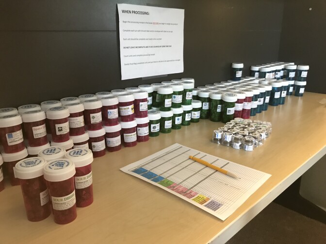 Vials of medical marijuana line a desk at the headquarters of a delivery service in south Orange County.