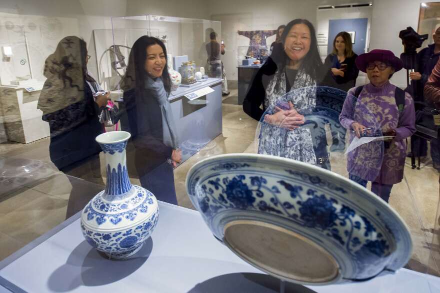 Christina Yu Yu, director of its USC Pacific Asia Museum, left, along with members of the media look at a cobalt-oxide porcelain charger and vase from the early Ming dynasty during a media tour of the newly renovated USC Pacific Asia Museum, December 6, 2017.  (Photo/Gus Ruelas)
