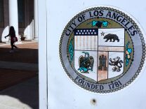 A woman walks through a plaza in front of City Hall in Los Angeles, California on August 22, 2017. 
The city of Los Angeles has sued the US Justice Department over threats to cut millions of dollars in federal funding for "sanctuary cities." The lawsuit joins similar legal challenges launched earlier this month by the city of San Francisco and the state of California against the department.   / AFP PHOTO / FREDERIC J. BROWN        (Photo credit should read FREDERIC J. BROWN/AFP/Getty Images)