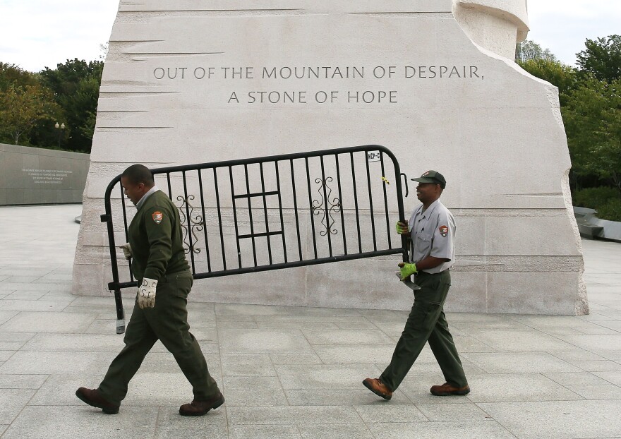 WASHINGTON, DC - OCTOBER 17:  U.S. Park Service workers carry a barricade that was used to close the Martin Luther King Memorial on the morning after a bipartisan bill was passed by the House and the Senate to reopen the government and raise the debt limit, on October 17, 2013 in Washington, DC. President Obama signed the bill into law, that will fund the government until January 15, 2014 and allow the government to pay bills until February 7, 2014.  (Photo by Mark Wilson/Getty Images)