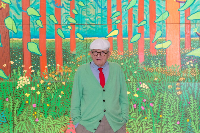 David Hockney poses in front of his painting "The Arrival Of Spring in Woldgate, East Yorkshire in 2011" at Centre Pompidou on September 26, 2017 in Paris, France.