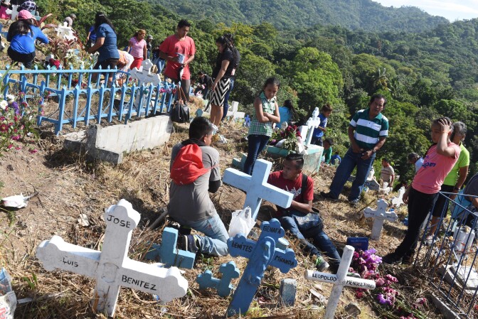 People visit the graves of their loved ones, during the commemoration of the day of the dead at a cemetery in Panchimalco, El Salvador on November 2, 2016.