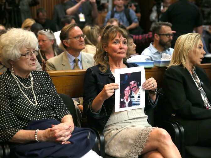 SACRAMENTO, CA - APRIL 27:  An attendee holds a photo of Cheri Domingo and her boyfriend Gregory Sanchez, who were killed in 1981, as she sits in the courtroom during the arraignment of Joseph James DeAngelo, the suspected "Golden State Killer" on April 27, 2018 in Sacramento, California.  DeAngelo, a 72-year-old former police officer, is believed to be the East Area Rapist who killed at least 12 people, raped over 45 women and burglarized hundreds of homes throughout California in the 1970s and 1980s.  (Photo by Justin Sullivan/Getty Images)
