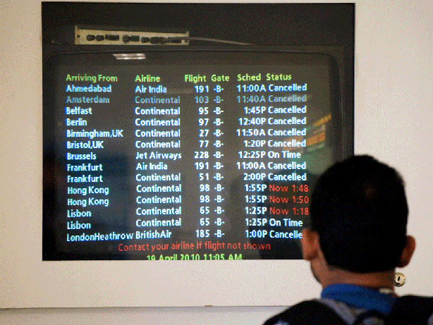 A man checks the arrivals board in Terminal B at Newark Liberty International Airport on Monday in Newark, N.J. The spate of flight cancellations over the past week is expected to wreak havoc on airline bottom lines, but U.S. airlines aren't expected to be as badly affected as their European counterparts.