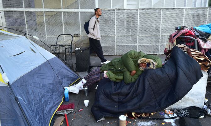 A homeless woman sleeps on a pile of belongings on the street near the Los Angeles Mission, hosting its annual Christmas meal for the homeless on December 22, 2017 in Los Angeles, California, home to one of the nation's largest homeless populations.
The Los Angeles Mission was established in 1936 as a soup kitchen and Christian outreach to homeless men on Skid Row, but the population of homeless in the nation's second largest city now include families, women and children. / AFP PHOTO / FREDERIC J. BROWN        (Photo credit should read FREDERIC J. BROWN/AFP/Getty Images)