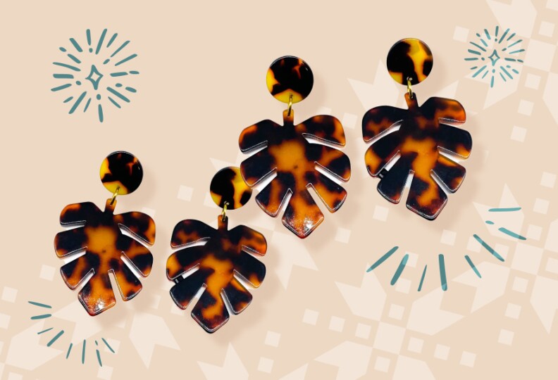 Brown and gold earrings shaped like monstera leaves