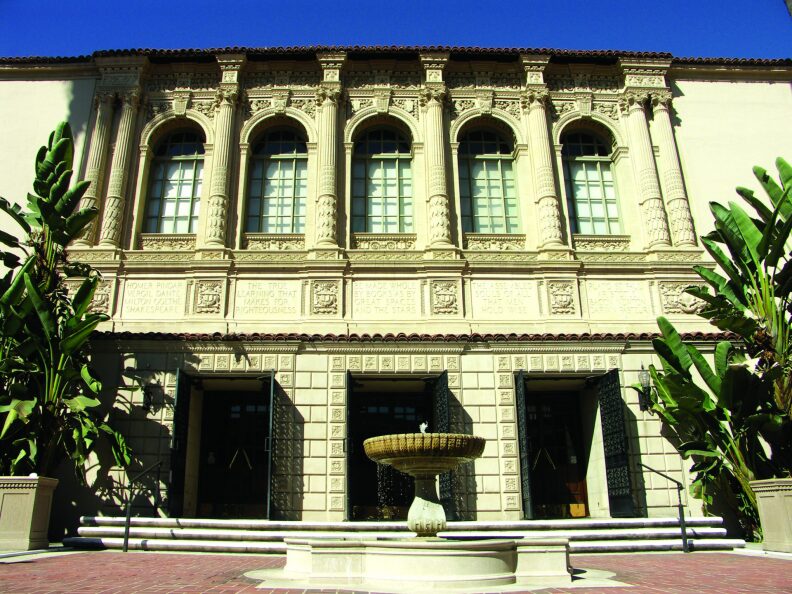 The front facade of Pasadena's Central Library, with a fountain in front of steps.