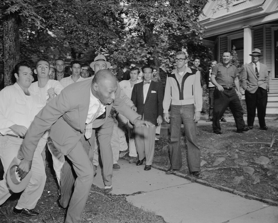 FILE - In this Sept. 23, 1957 file photo, a reporter from the Tri-State Defender, Alex Wilson, is shoved by an angry mob of white people near Central High School in Little Rock, Ark. The fight started when nine black students gained entrance to the school as the Army enforced integration. Five decades and $1 billion after an infamous racial episode made Little Rock a symbol of school segregation, the legal fight to ensure all of its children receive equal access to education has ended. (AP Photo/File)