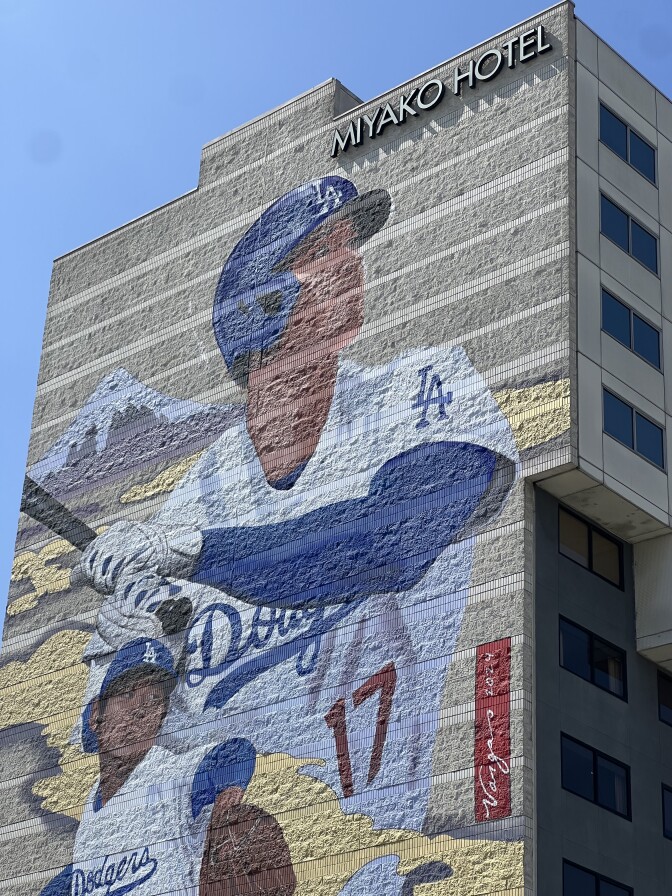 The Robert Vargas mural on the side of the Miyako Hotel of two Shohei Ohtani's one pitching, a larger one hitting taken from across the street in front of the "Far Bar"